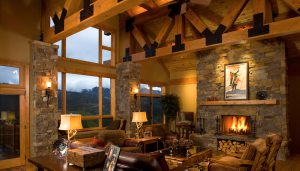 luxury mountain home interior with exposed beams and picture windows