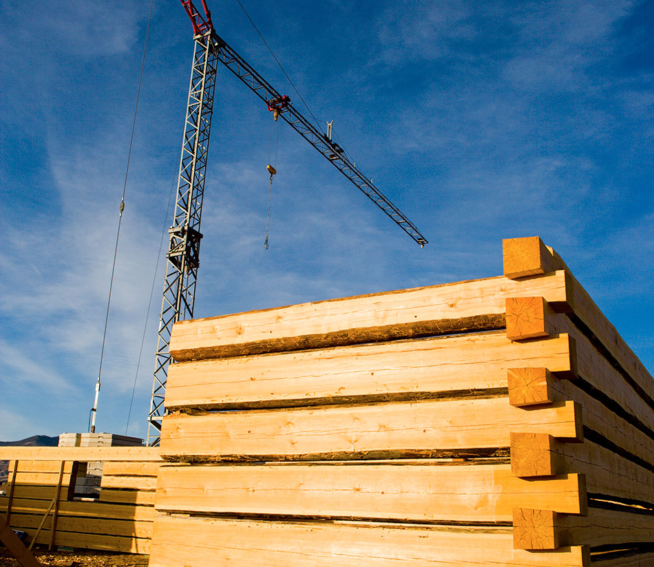 a crane is used to construct a log residence