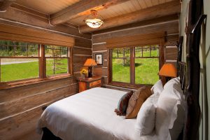 summer cabin with scenic forest shot from inside cozy bedroom