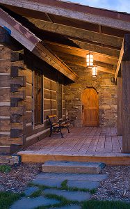 log cabin construction Big Sky, Montana front door and deck with stone wall