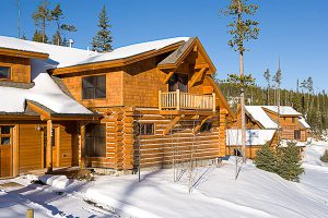 log cabin construction Big Sky, Montana with balcony and snowy yard