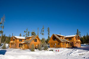 two log cabin construction big sky Montana exteriors with snow on the ground