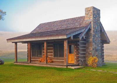 rmr group construction petite cabin exterior with rustic fireplace stone