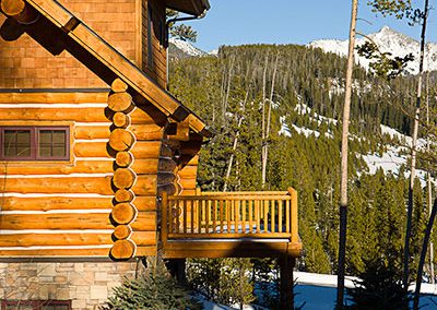 log cabin construction in Big Sky, Montana close up of balcony with snowy forest in background