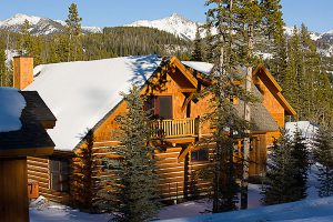log cabin construction in Big Sky, Montana upstairs balcony exposed with snowy forest and mountain in background