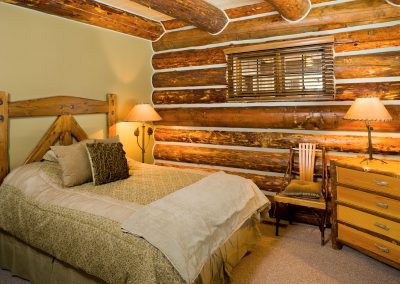 prc 104 interior bedroom with log wall and log ceiling beams
