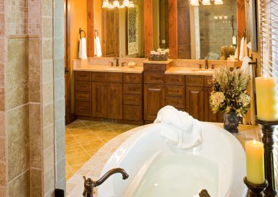 black bull clubhouse bathroom with bathtub wooden cabinetry and candles