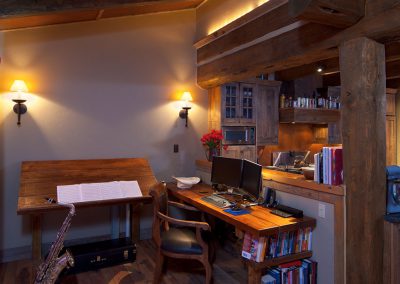 interior of a house modeled in the style of an old forest service cabin kitchen and adjacent study area with saxophone