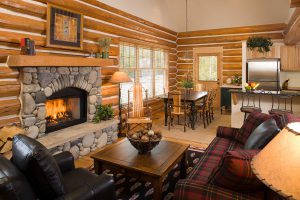 rmr group construction interiors living room and kitchen with stone fireplace and log walls