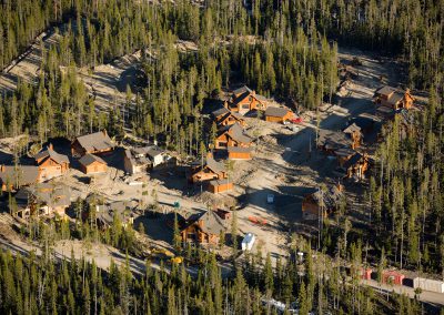 powder ridge aerial view with log cabins in thick wooded forest